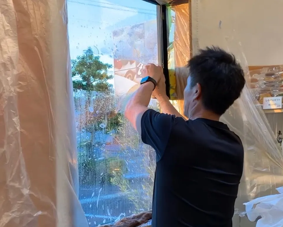窓ガラスフィルム圧着中